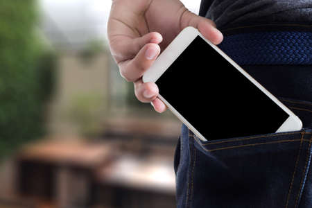 Young handsome poses hand Mobile Phone Pocket Communication Copy Spaceの写真素材