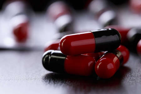 Close-up  Pills red anf black on Tablets. Medical background Assorted pharmaceutical medicine pillsの写真素材