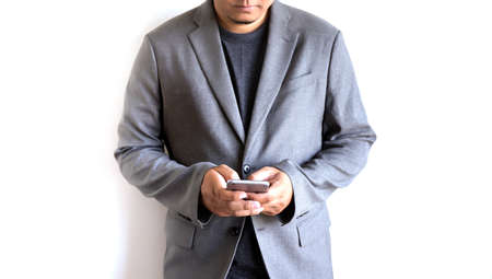 businessman working Happy holding smart phone and smiling. Looking phone and copy spaceの写真素材