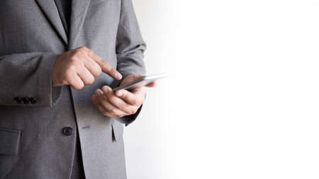 businessman working Happy holding smart phone and smiling. Looking phone and copy spaceの写真素材