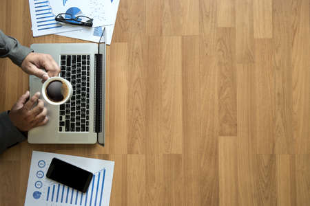 Top view man used of laptop  hands on a wooden desktop and copy spaceの写真素材