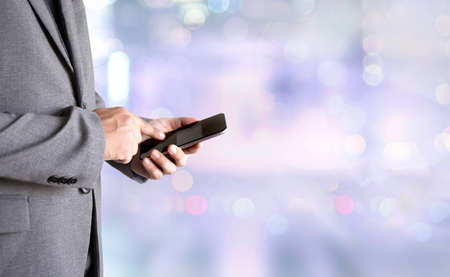 person holding a smartphone on blurred cityscape background