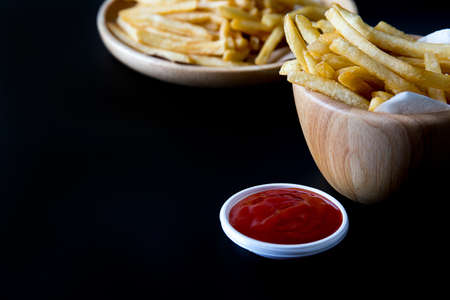 Tasty french fries with ketchup on a black background