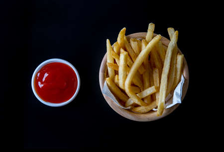 Tasty french fries with ketchup on a black backgroundの写真素材