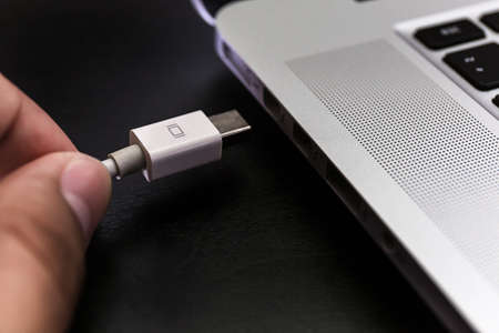 USB flash cards and thumb drive or stick Virtual memory storage with USB cable into slot  laptop computerの写真素材