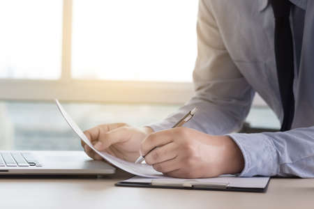 A businessman reading the financial graph documents to analyse a job plan successfulnessの写真素材