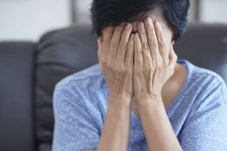 Elderly woman suffering from headache Depressed  at homeの写真素材
