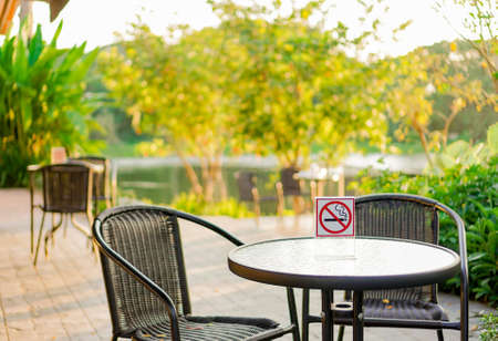 smoking area sign against smoking a cigarette in park and coffee shopの写真素材