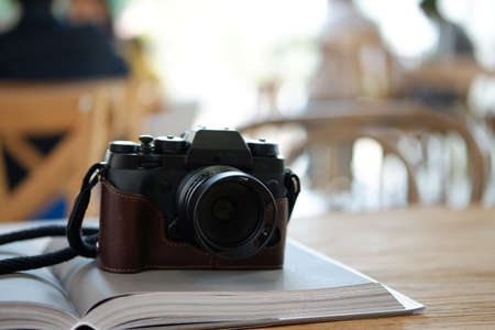 old camera on book on table cafe background