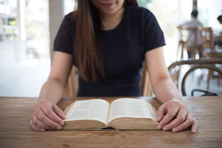 beautiful girl happy to sit reading a book Close-up of female relaxing in coffee shop cup of tea