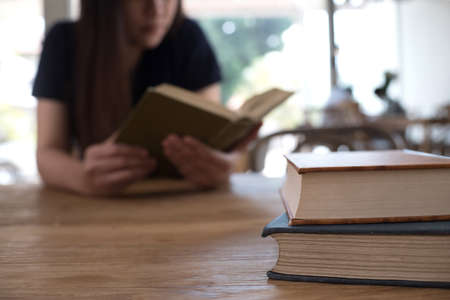 beautiful girl happy to sit reading a book Close-up of female relaxing in coffee shop cup of teaの写真素材