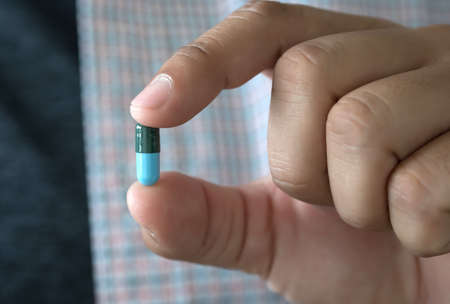 Medicine and health care concept man pours the pills out of the bottle holding medicine