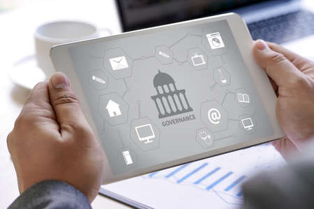 GOVERNANCE and building, Authority Computing Computer Laptop with screen on table Silhouette and filter sunの写真素材