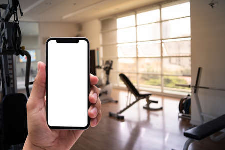 Young man Hand holding smartphone in gym to  fitness phone fitness exercise conceptの写真素材