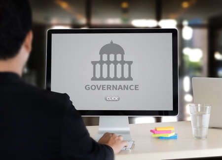 GOVERNANCE and building, Authority Computing Computer Laptop with screen on table Silhouette and filter sunの写真素材