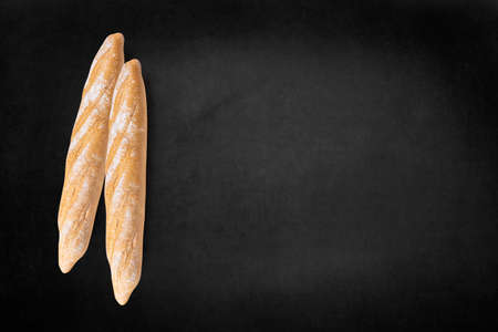 loaves of bread on dark board, top view free text space.の写真素材