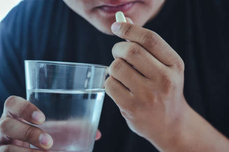 Unhealthy sick Mans hands with pills on healthcare concept treatmentの写真素材