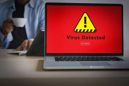 Hacker Protection Concept Man working on laptop Virus Detected Alert Digital Browsing Firewallの写真素材