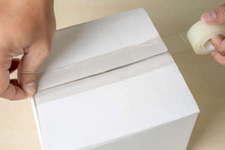 close-up man packing box,  adhesive tape indoorsの写真素材