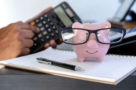 piggybank And Calculator On Desk business document calculator counting money
