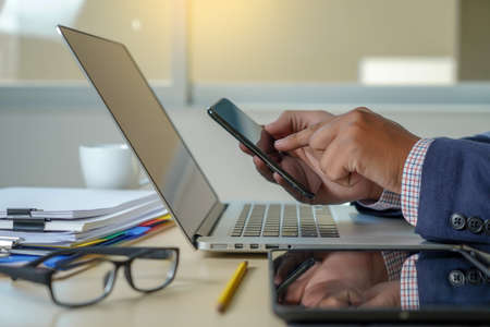 double exposure of business man hand working on laptop computer on wooden desk with social media network diagramの写真素材