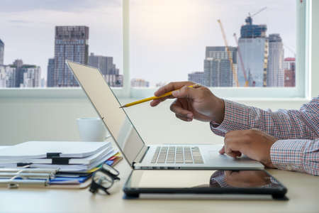 double exposure of business man hand working on laptop computer on wooden desk with social media network diagramの写真素材