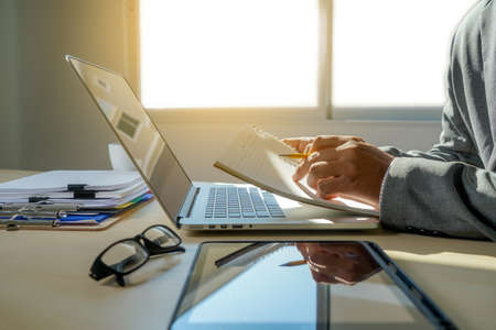double exposure of business man hand working on laptop computer on wooden desk with social media network diagramの写真素材