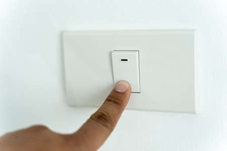 Close up of man finger is turning on or off on light switch