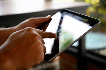 businessman hand working on tablet on wooden desk tablet with blank screen mockup Digital tablet computerの写真素材