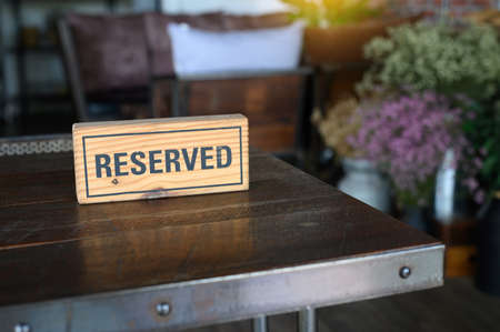 Restaurant reserved table sign Reserved Table. A tag of reservation placed on the wood tableの写真素材