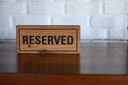 Restaurant reserved table sign Reserved Table. A tag of reservation placed on the wood tableの写真素材