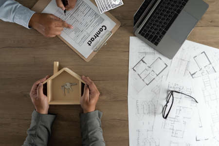 Real estate agent signing a contract over a house key  real estate  home loanの写真素材