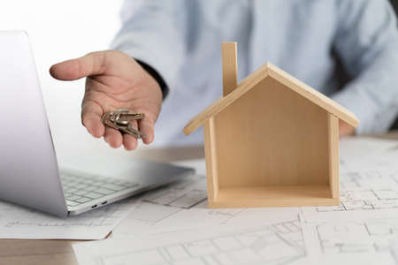 Real estate agent signing a contract over a house key  real estate  home loan