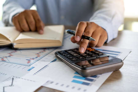 businessman working using a calculator finance accounting concept achievement to balance man assistant accountingの写真素材