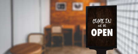 Come in Weâre Openâ on cafe waiter standing in front of coffee shop vintage retro sign Open sign at coffeeの写真素材