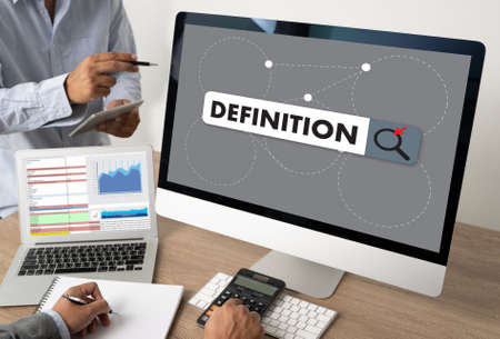 DEFINITION Business team hands at work with financial reports and a laptopの写真素材