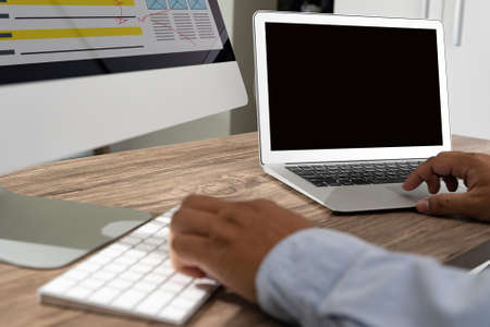 Man of business man hand working on laptop computer on wooden desk Laptop with blank screen on table.の写真素材