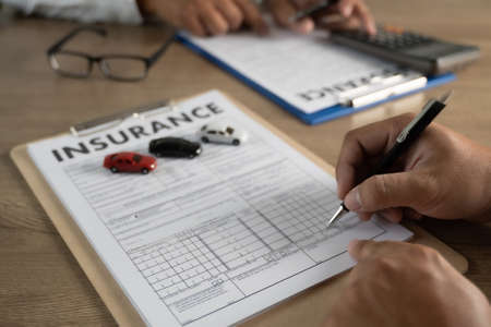 insurance policy and pointing examining insurance policy car insurance detail to customerの写真素材
