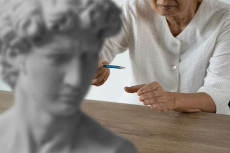 Attentive senior woman Art and Sculpture fun at the creative workshop Woman painting