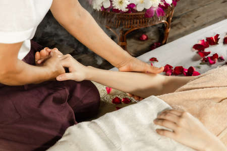 Asian woman enjoying a salt scrub massage at spa. Healthcare spa and massage thai concept  Girl receiving holistic massage treatment thai masseuse woman getting massageの写真素材