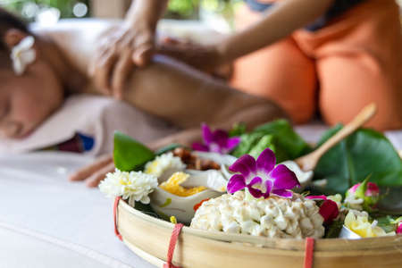 Asian woman enjoying a salt scrub massage at spa. Healthcare spa and massage thai concept  Girl receiving holistic massage treatment thai masseuse woman getting massageの写真素材