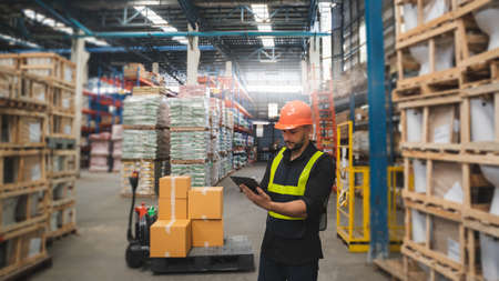 Man portrait happy professional warehouse worker check box stock good package in store worker safetyの写真素材