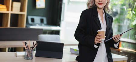 Young beautiful Asian woman smiling and happy, showing presenting credit card online shopping using with mobile phone app pay online copy spaceの写真素材