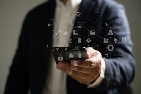 Man's hand holding a smartphone with media icons and symbols and application icons for multitasking.