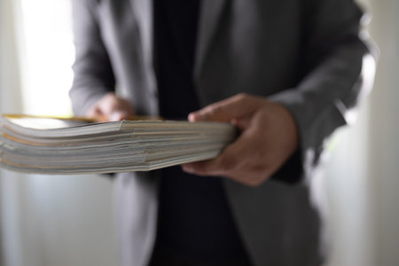 man holding a magazine publication page media stack to stack communication research data to learn advertising and banner space objectsの写真素材