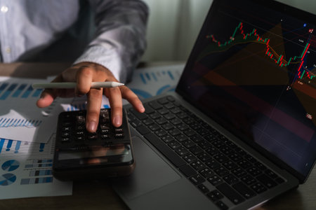 close-up of a businessman using a computer laptop to analyze finances and calculate investment data...