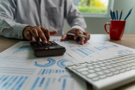 man using a calculator accountant working on desk budget and loan Close up Accounting analysis, tax finance, bank income savings budgetの写真素材