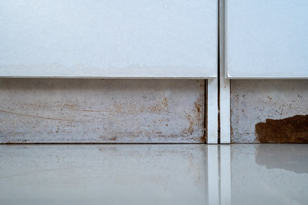the closet with a white cabinet and a brown stain on the floor. The cabinet has two drawers After the floodの写真素材