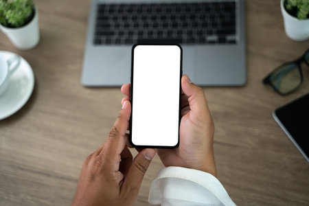 Top view Mockup image hand using a smartphone man Holding Cell Phone With Blank Screenの写真素材