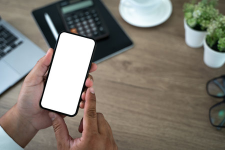 Top view Mockup image hand using a smartphone man Holding Cell Phone With Blank Screenの写真素材